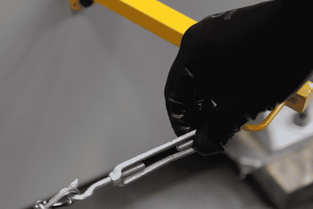 Close up of a hand turning the wire tension on a rolling machine