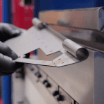 Close up metal being curled on a press brake