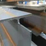 A freshly cut steel beam, with a segment cut out of it.