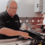 Image of a Selmach engineer inside the press brake conducting general maintenance on the backgauge