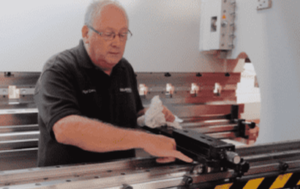 Image of a Selmach engineer inside the press brake conducting general maintenance on the backgauge