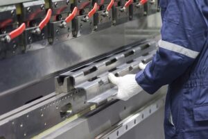 Image of gloved hands working at a pressbrake