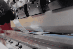 A piece of metal being curved via bump bending on a press brake