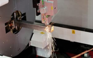 A close-up shot of a Raytools Laser Head cutting on a Tube Laser Cutter